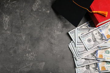Flat lay composition with dollars and student graduation hat on stone background, space for text....