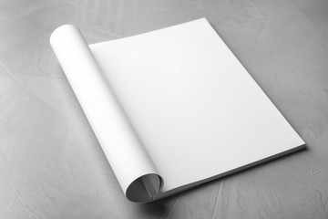 Blank open book on light grey stone background. Mock up for design