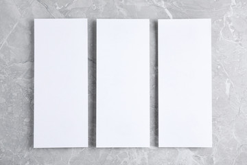 Blank palm cards on light grey marble background, flat lay. Mock up for design