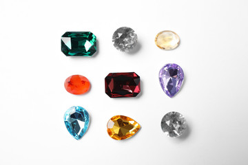 Different beautiful gemstones on white background, top view