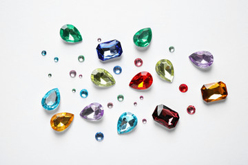 Different beautiful gemstones on white background, top view