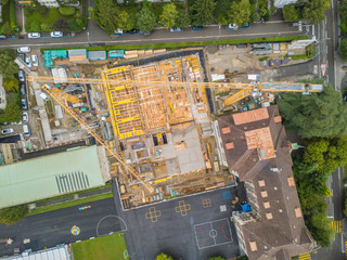 Aerial view of construction site with large crane in European town.