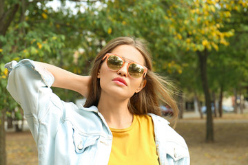 Young woman wearing stylish sunglasses in park