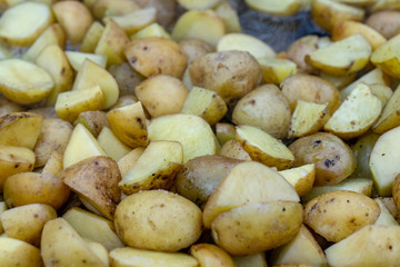 closeup homemade fried potato. Cooking fried potatoes in outdoor conditions on fire. Fire fried potatoes. Simple food. Potatoes in a black pan.