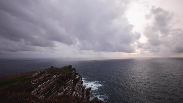 footage of bray head on the ring of kerry in the south coast of ireland on a stormy day showing battering waves and green grass on rocky coastline