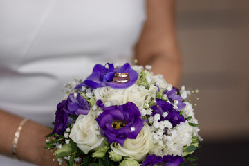 Obraz na płótnie Canvas Wedding rings lying on the bride's bouquet
