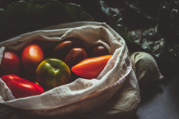 Zero waste concept. Small tomatoes in a cotton bag. Green, yellow, red tomatoes.