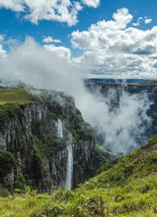 Obraz premium Waterfall landscape on cliff in foggy day
