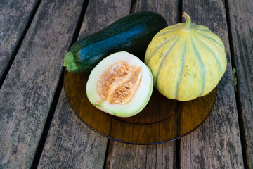 Gmo free melons and zucchini on a wooden table