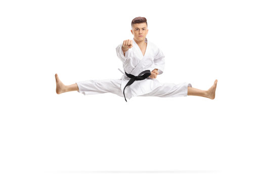 Guy in kimono jumping and doing martial art split