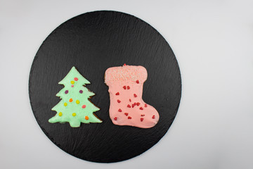 Christmas homemade gingerbread cookies on a white background. Sweet colored gingerbread cookies, place for text. Christmas tree and boot. Copyspace