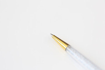 Naklejka premium Macro photo of gold and crystal pen on white background