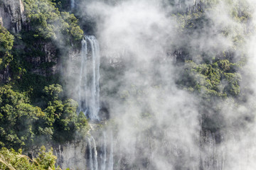 Waterfall landscape on cliff in foggy day