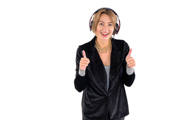 Cheerful female DJ in headphones and retro costume for disco 80s  shows thumbs up standing on a...