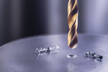 metal drill bit make holes in steel billet on industrial drilling machine. Metal work industry....