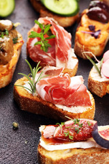 Assorted bruschetta with various toppings. Appetizing bruschetta or brie crostini. Variety of small sandwiches. Mix bruschetta on table