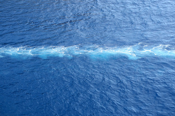 White foam track in the blue sea
