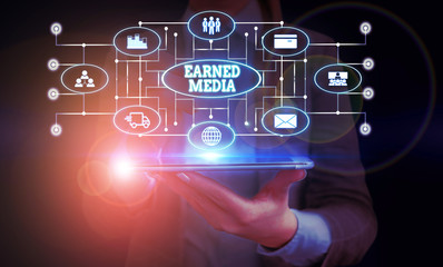 Conceptual hand writing showing Earned Media. Concept meaning Publicity gained through promotional efforts by multimedia Woman wear work suit presenting presentation smart device