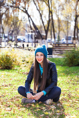 Happy woman in black leather jacket and blue knitted hat