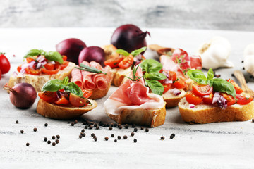 Assorted bruschetta with various toppings. Appetizing bruschetta or crudo crostini. Variety of small sandwiches. Mix bruschetta on table