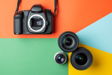SLR camera with a set of different lenses on a colored background, the choice of device for the...