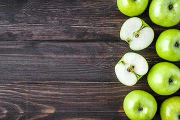 Ripe green apples and apple slices on old wooden background.Vegetables for diet and healthy eating.Organic food. Place for text. Top view