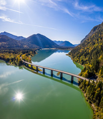 Scenic aerial view of the bridge over Lake Sylvenstein with beautiful reflections. Alps Karwendel Mountains in the back. Autumn scenery of Bavaria, Germany