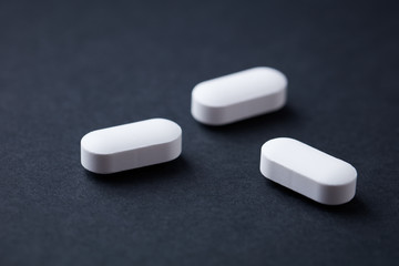 Magnesium with Vitamin B6 Tablets on  black paper background. Dietary supplement. Close up. 