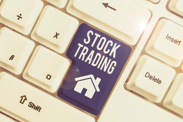 Conceptual hand writing showing Stock Trading. Concept meaning Buy and Sell of Securities Electronically on the Exchange Floor White pc keyboard with note paper above the white background