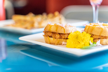 Chicken and waffle slider sandwich. An inventive take on a southern classic served in an upscale restaurant for brunch or breakfast. 