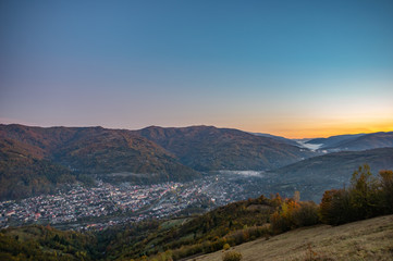 Panorama of a small town among the mountains in the autumn afternoon