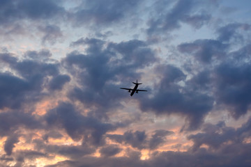 Wonderful color of the sky. Red and blue colors in the clouds. Airplane in the clouds