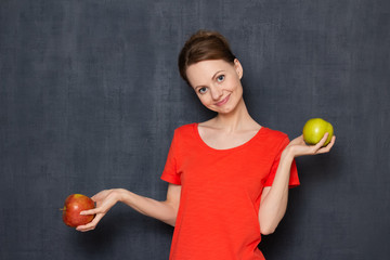 Portrait of happy young pretty woman holding apples in hands