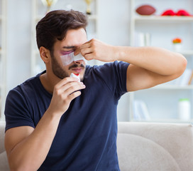 Young man recovering healing at home after plastic surgery nose