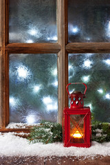 Christmas composition with lantern and frost window, selective focus