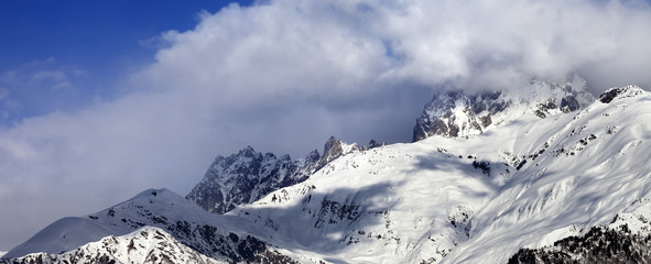 Fototapeta na wymiar Snow mountains in clouds in winter sun day