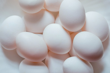 Huevos blancos ecológicos en un recipiente blanco.