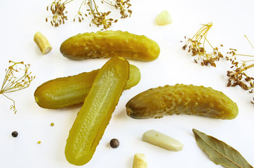 Pickled cucumbers on a white background surrounded by spices