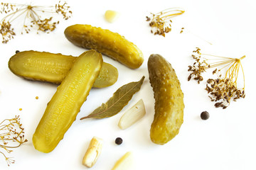 Pickled cucumbers on a white background surrounded by spices