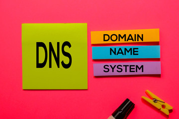 DNS - Domain Name System acronym write on sticky notes isolated on Pink background.