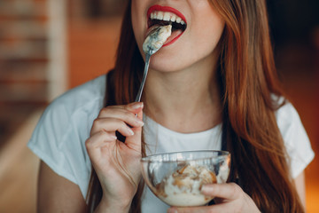 Young woman eating ice cream with a spoon