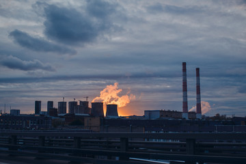 Industrial landscape and smoke from the chimneys on sunset background