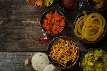 Homemade Diwali foods- snacks and desserts on festive background