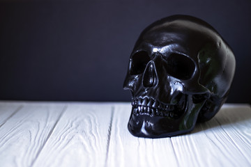 Black skull on the table closeup, horror concept, Halloween