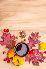 Autumn cozy mood composition. Hot tea in ceramic glass, fall leaves, pumpkins, briar, hazelnuts