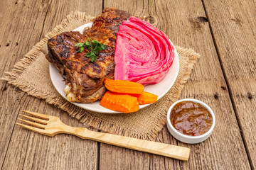 BBQ pork ribs with fermented cabbage, baked carrot, fresh parsley