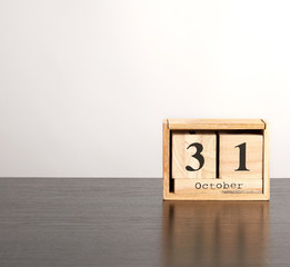 wooden calendar of cubes with the date October 31 on a black table