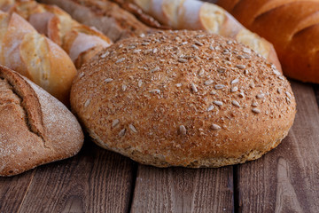 Assortment of baked bread on wooden table background