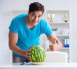 Fototapeta premium Man eating watermelon at home