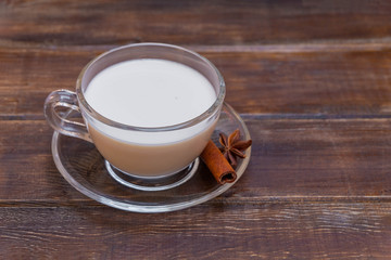 Warm winter drink with spices indian masala tea on wooden background with copy space
